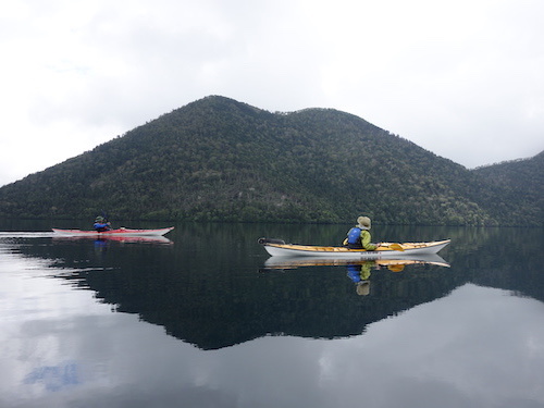 鏡のような然別湖の湖面に浮かぶ2艇のカヤックを写したツアー写真
