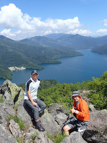 白雲山の山頂に立つ登山者の写真